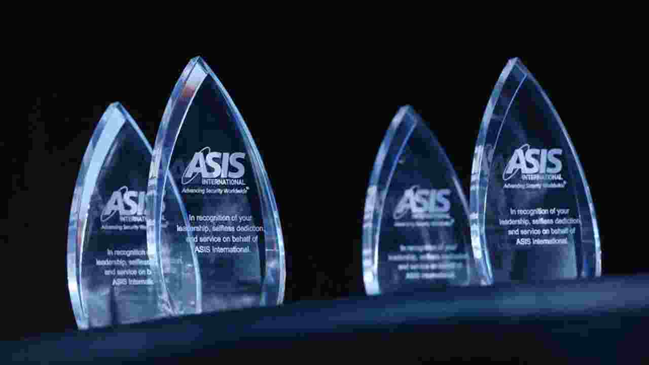 Glass awards with the ASIS logo etched on them sit on a black table.  ASIS is recognizes outstanding individuals and chapters for their accomplishments during 2021-22. 
