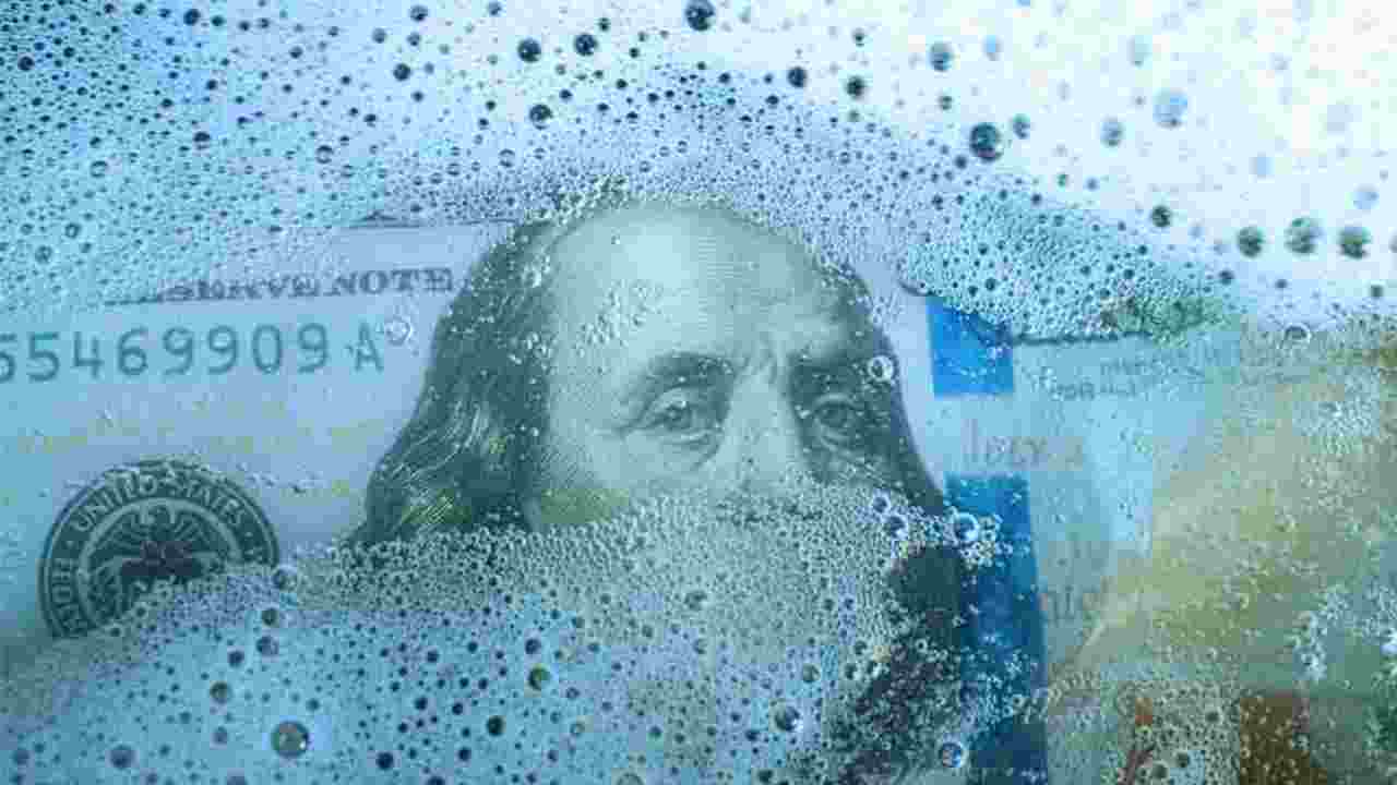 close-up photo of a one hundred dollar bill with soap suds over Ben Franklin's face