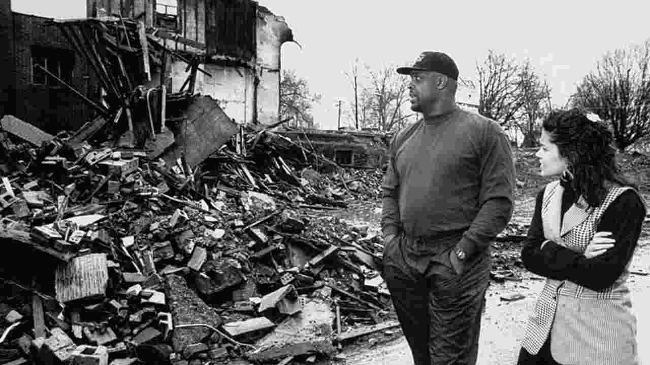 Former football player Reggie White and his wife Sara walked past burnt rubble of the Inner City Church where he served as an assistant pastor at the church.