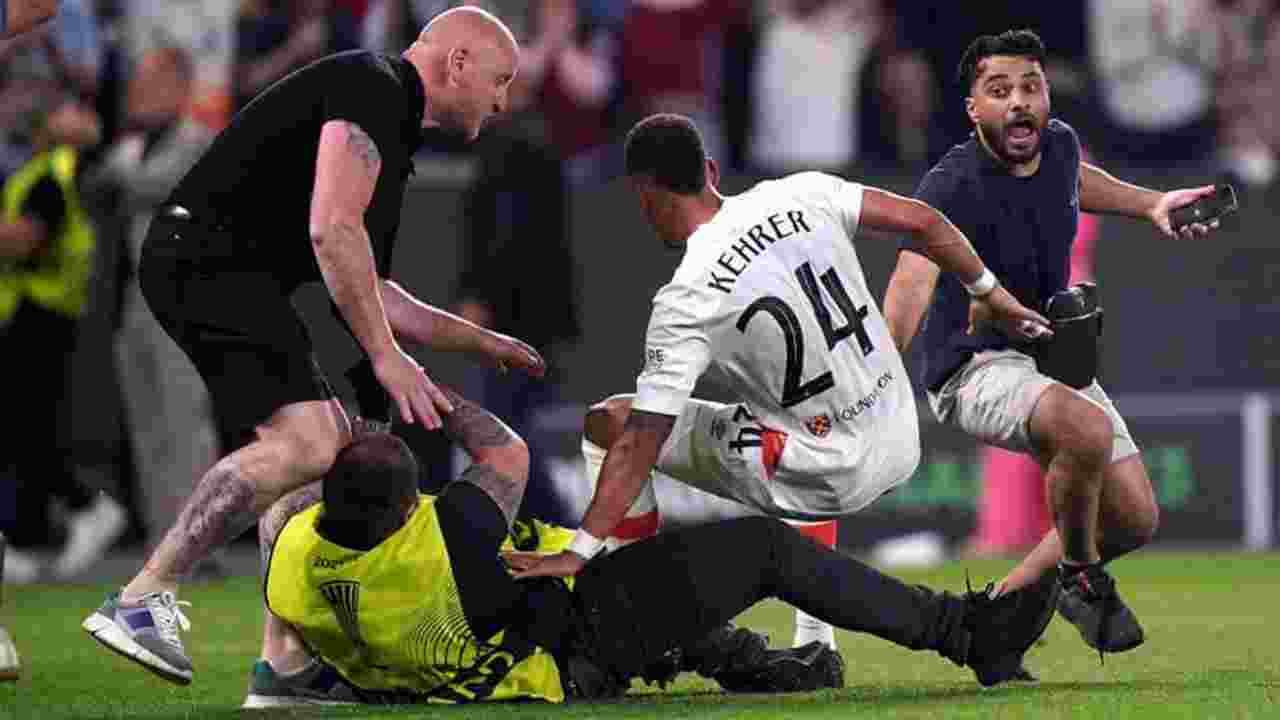 Photo of West Ham United's Thilo Kehrer is accidentally tackled by a security guard as pitch invaders enter the field following the UEFA Europa Conference League Final at Fortuna Arena in Prague.