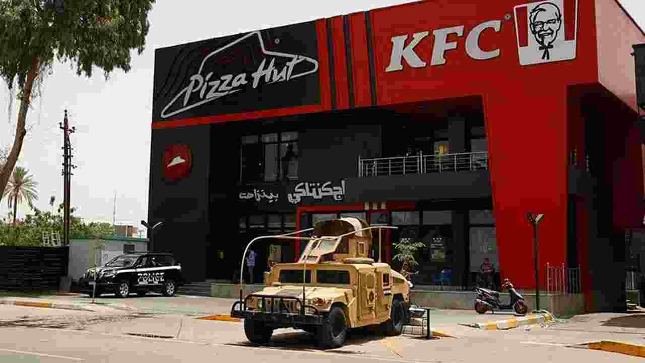 Iraqi security forces vehicles are stationed in front of a Kentucky Fried Chicken (KFC) and Pizza Hut fast food restaurants in the Al-Jadriya neighbourhood in Baghdad on May 30, 2024. 